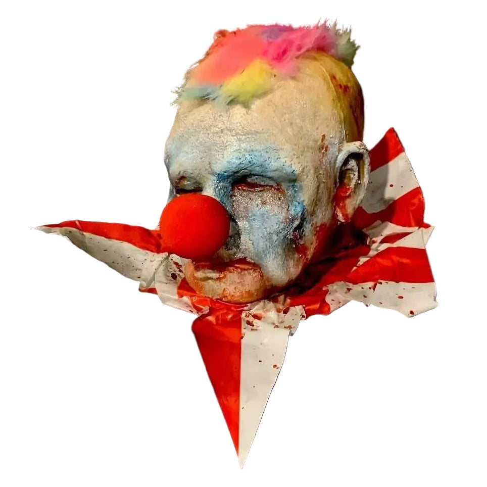 Horror clown head prop with colorful hair and red nose on a white background