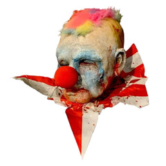 Horror clown head prop with colorful hair and red nose on a white background