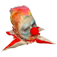Horror clown head prop with colorful hair and red nose on a white background